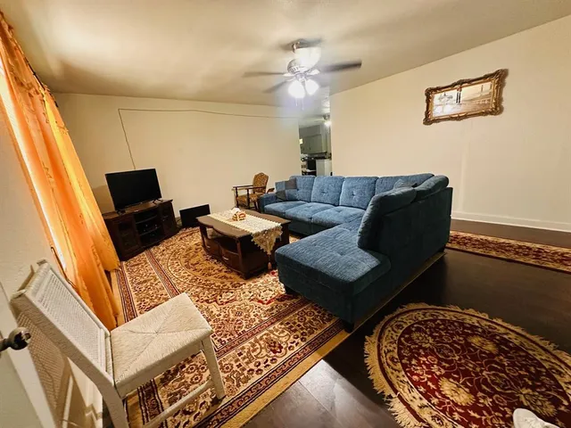 a living room with furniture a rug and a flat screen tv