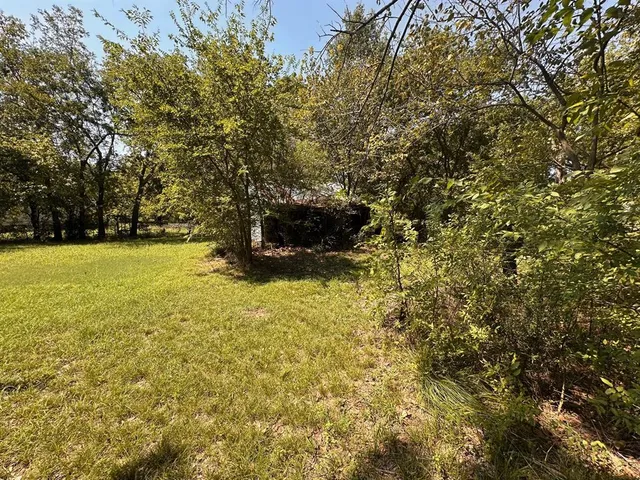a view of yard with swimming pool and trees