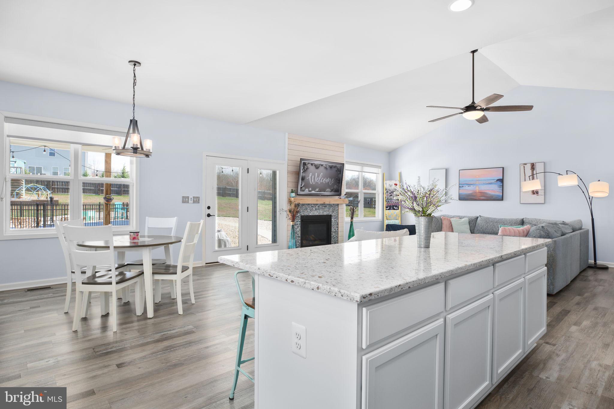 9564 Blackbird Loop Culpeper, VA 22701 - Photo 4 of 52 a kitchen with stainless steel appliances granite countertop a sink dishwasher a dining table and chairs with wooden floor