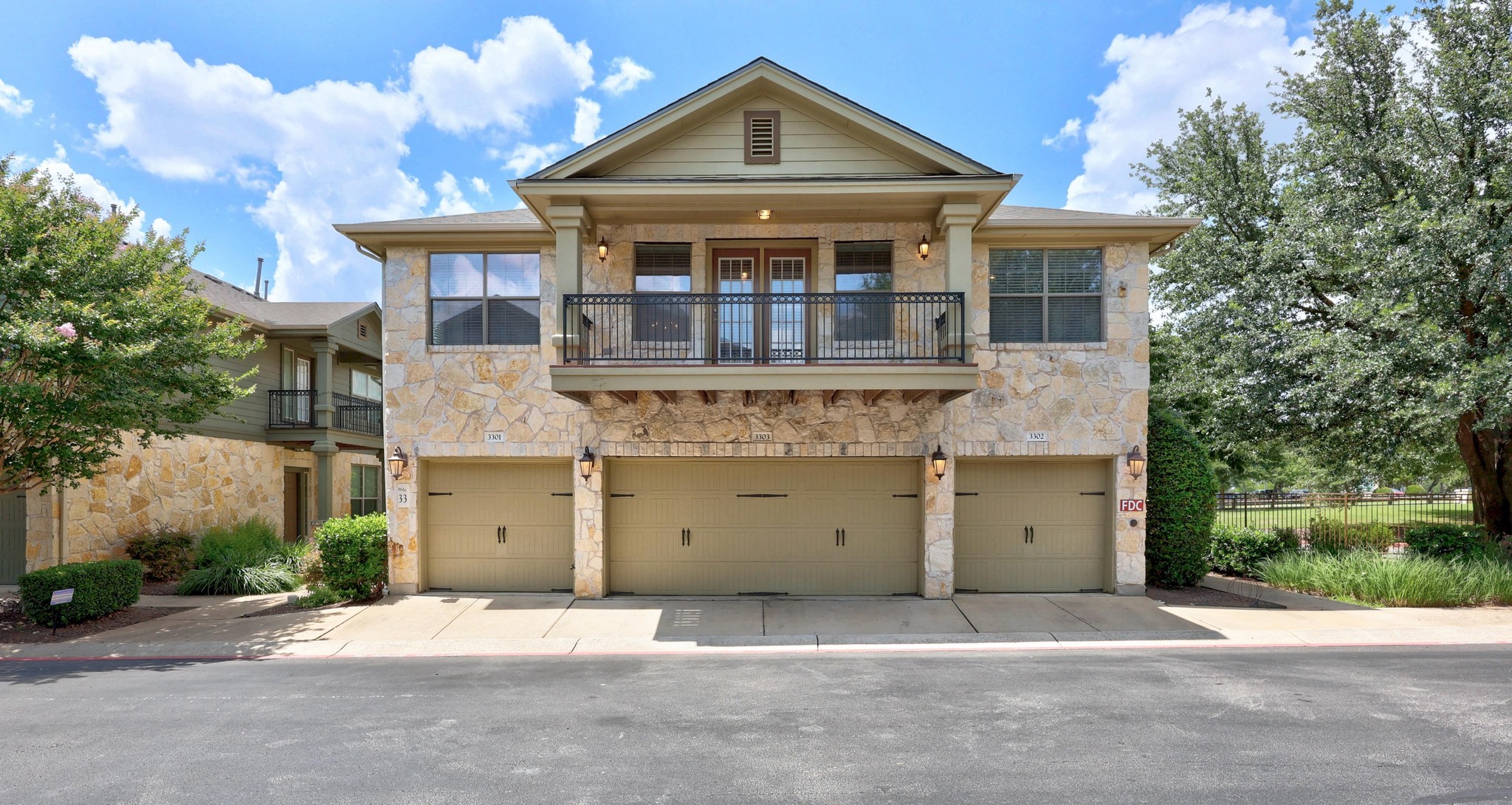 14815 Avery Ranch Boulevard, Unit 3301 Austin, TX 78717 - Photo 1 of 1 View of front of condo stone siding, a balcony, driveway, and a garage