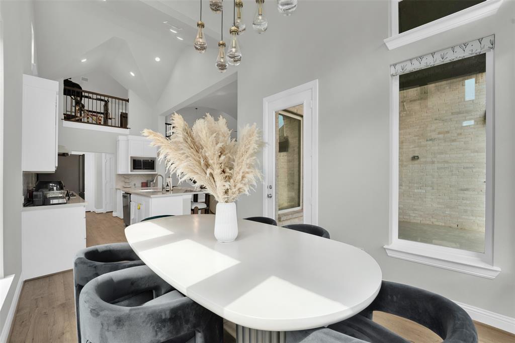 3520 Helios Lane Corinth, TX 76208 - Photo 14 of 37 Spacious dining area featuring a modern oval table, contemporary light fixture, and wood-finish flooring
