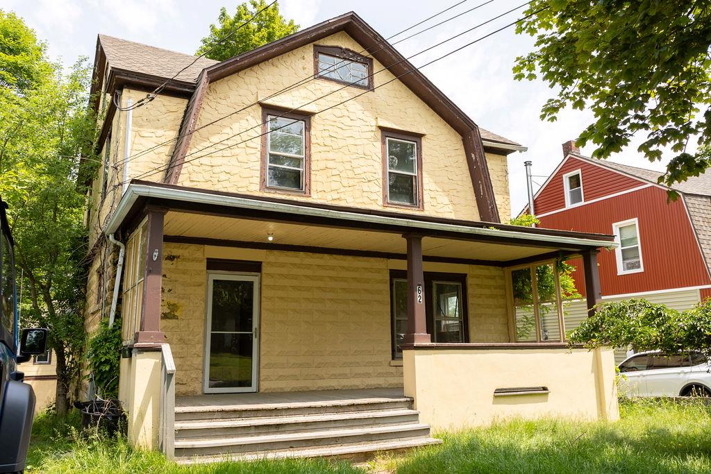 a view of a house with a yard and large tree