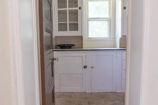 a kitchen with granite countertop white cabinets and window