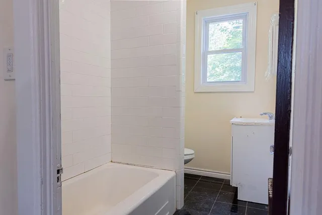 a bathroom with a tub and window