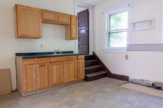 a view of a kitchen with wooden floor and cabinets