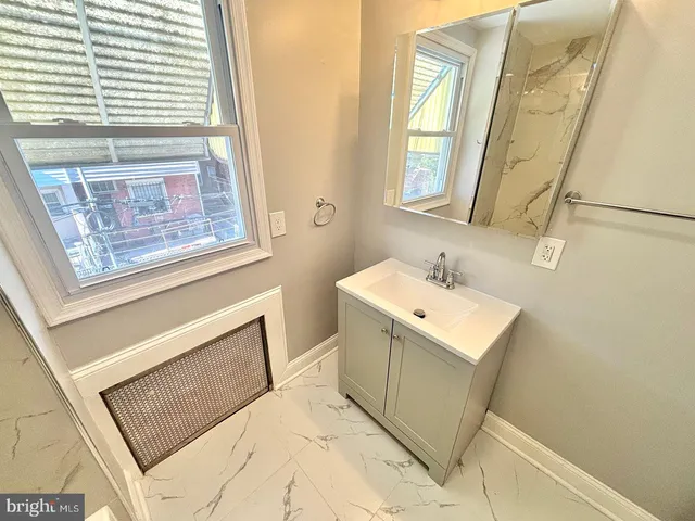 a bathroom with a sink mirror and a window
