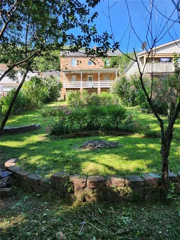 a backyard of a house with a yard and outdoor seating