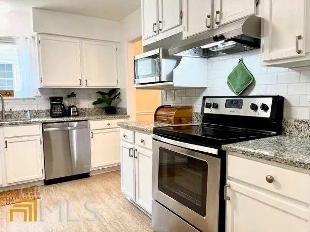 a kitchen with a refrigerator a stove a sink and a window