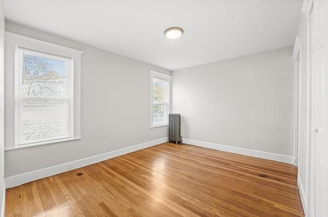 40 Ripley Road, Unit 2 Boston, MA 02121 - Photo 17 of 25 a view of an empty room with wooden floor and a window