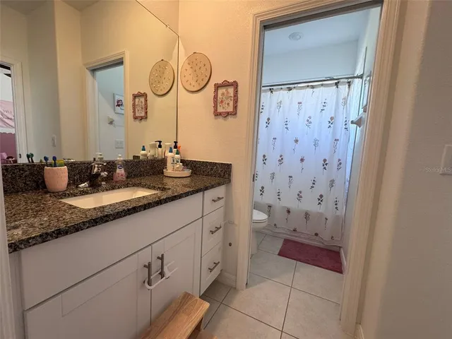 a view of a backyard with couches plants and wooden fence