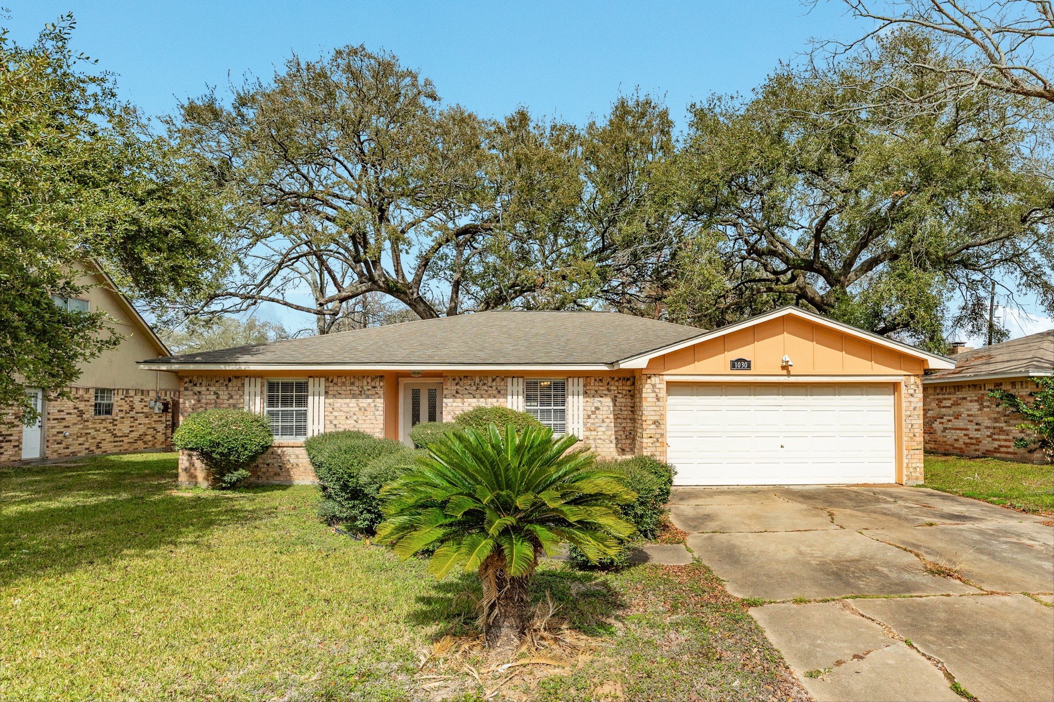 1030 Maple Street Clute, TX 77531 - Photo 1 of 25 a front view of a house with a garden