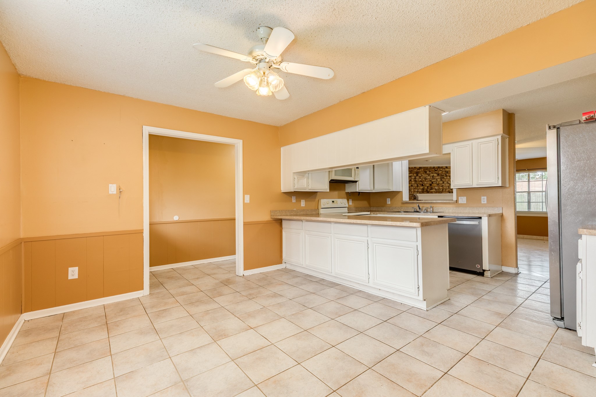 1030 Maple Street Clute, TX 77531 - Photo 11 of 25 a kitchen with stainless steel appliances granite countertop a refrigerator sink and white cabinets