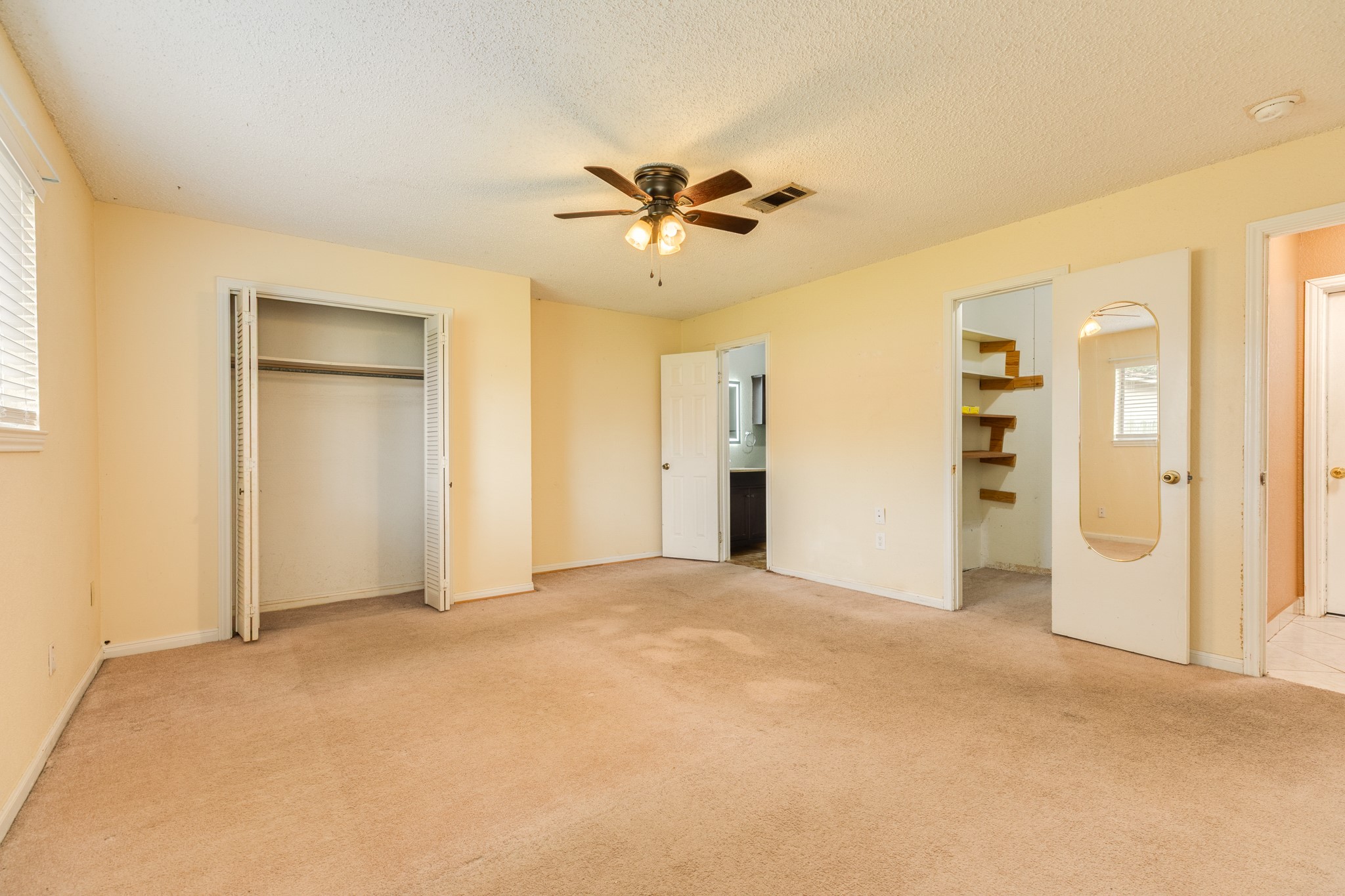 1030 Maple Street Clute, TX 77531 - Photo 16 of 25 a view of a big room with closet and a chandelier fan