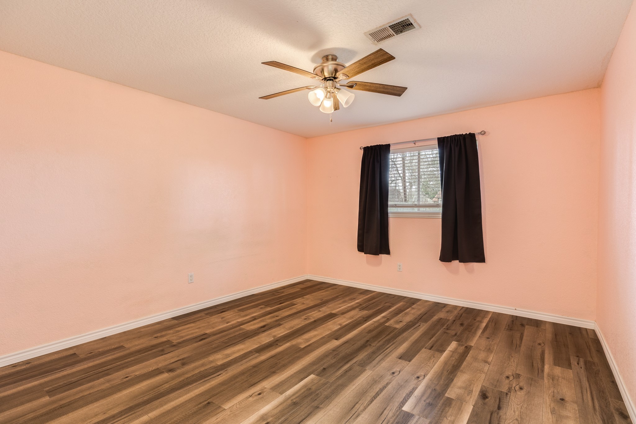 1030 Maple Street Clute, TX 77531 - Photo 20 of 25 a view of a room with wooden floor and ceiling fan