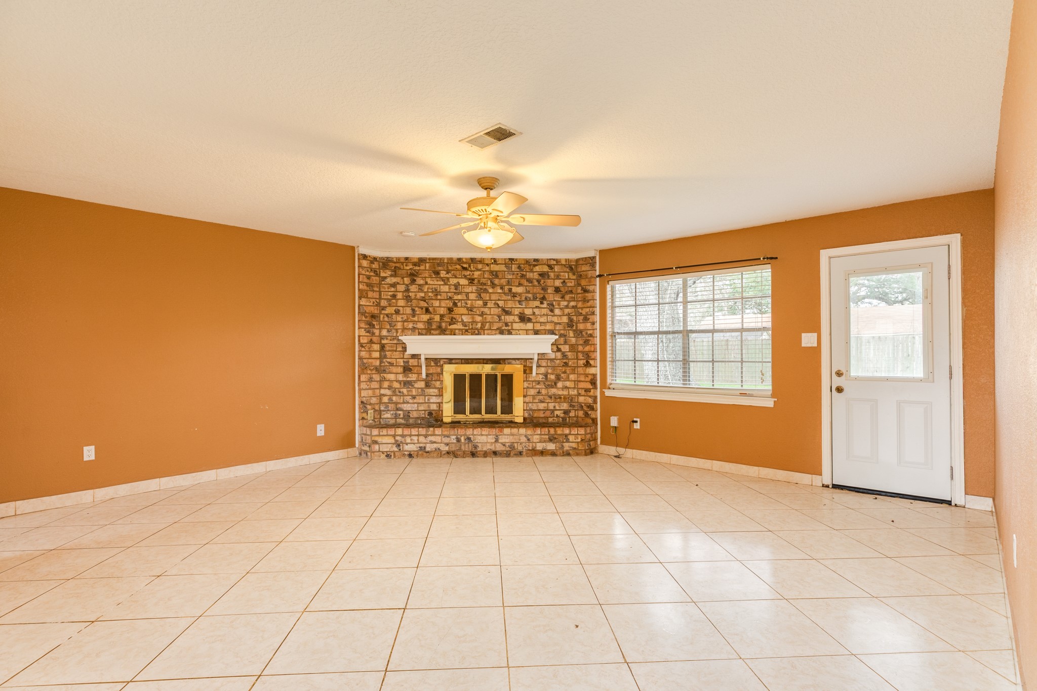 1030 Maple Street Clute, TX 77531 - Photo 5 of 25 a view of an empty room with a fireplace and a window