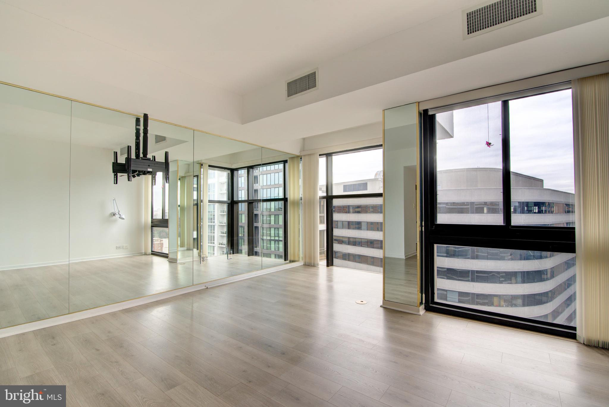 1530 Key Boulevard, Unit 1321 Arlington, VA 22209 - Photo 14 of 42 a view of an empty room with wooden floor and a window