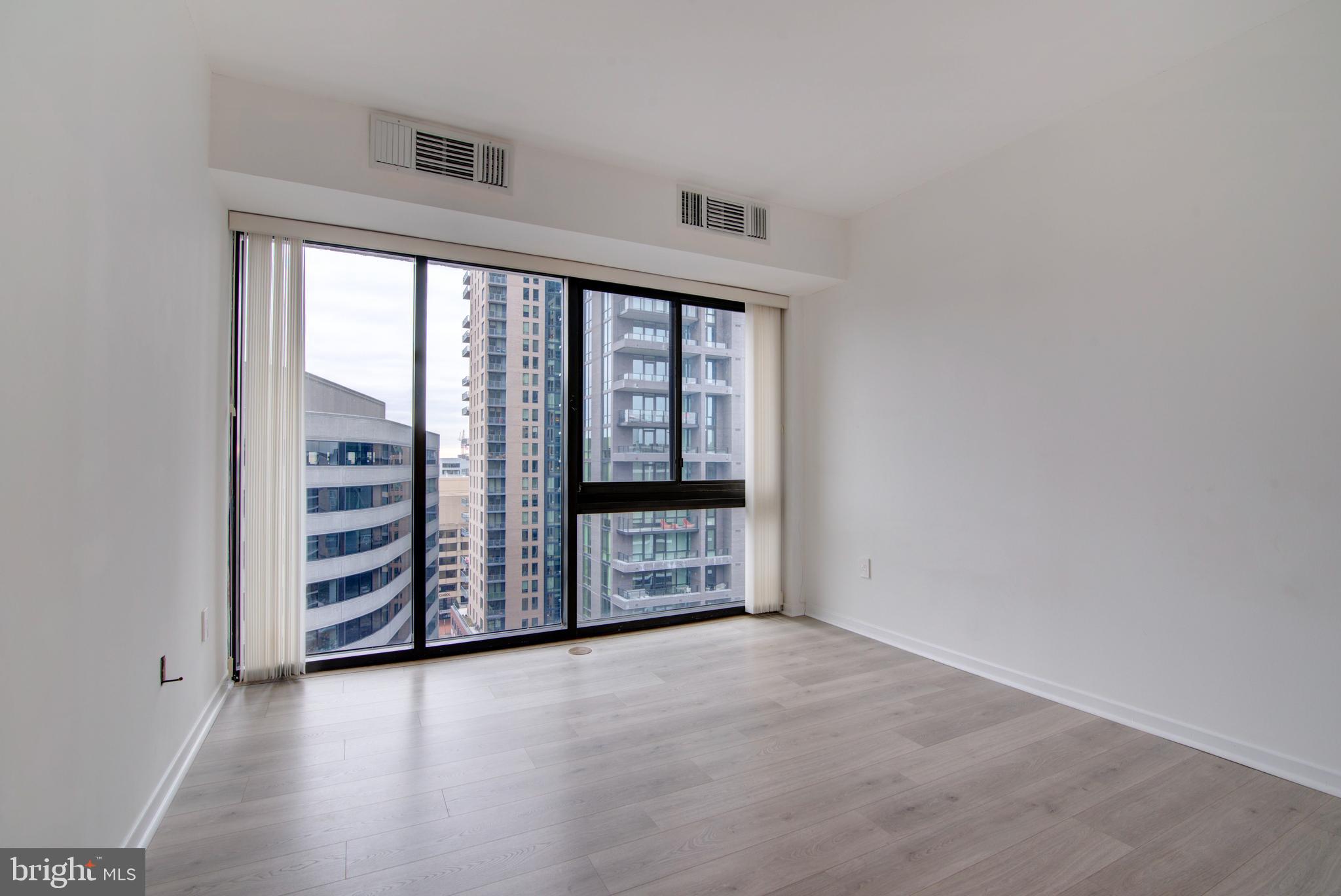 1530 Key Boulevard, Unit 1321 Arlington, VA 22209 - Photo 20 of 42 wooden floor in an empty room with a window