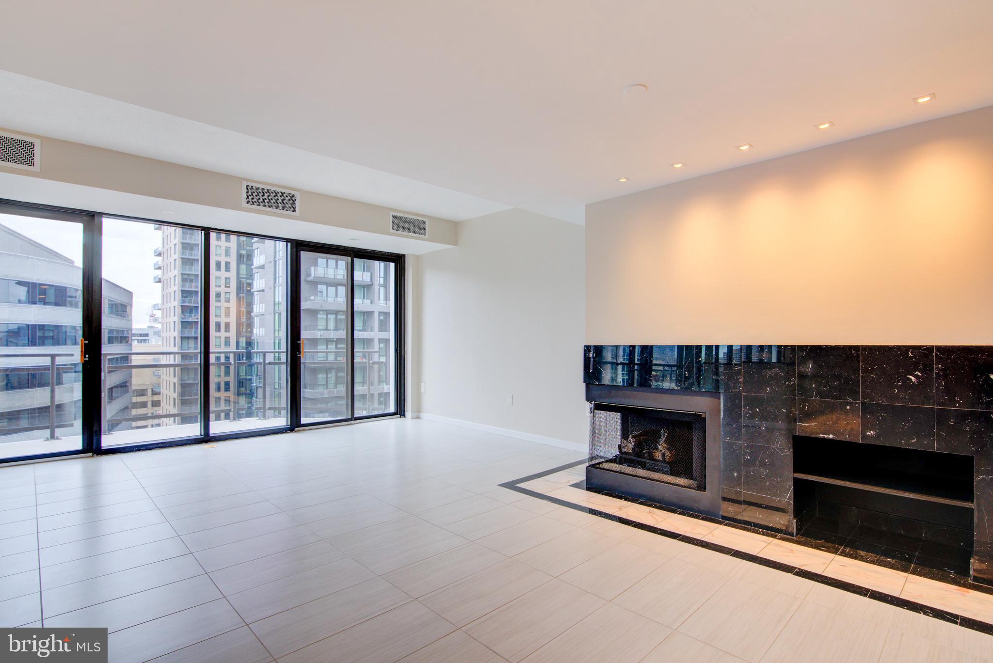 1530 Key Boulevard, Unit 1321 Arlington, VA 22209 - Photo 2 of 42 a view of an empty room with a fireplace and a window