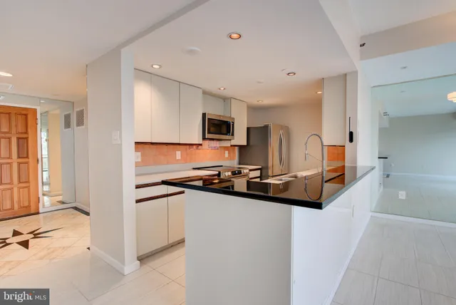 a kitchen with stainless steel appliances granite countertop a sink and wooden cabinets