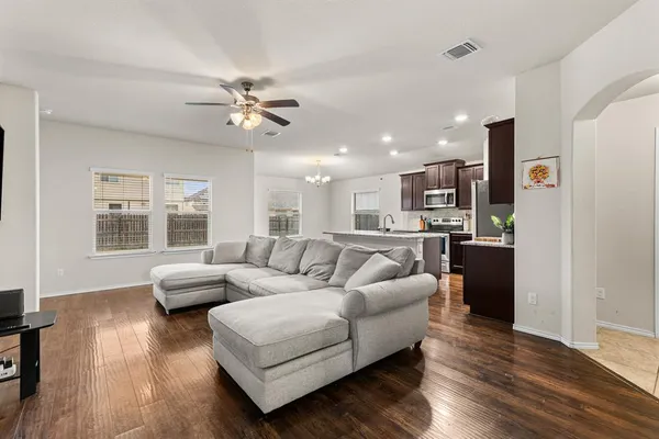 a living room with furniture and a large window with kitchen view