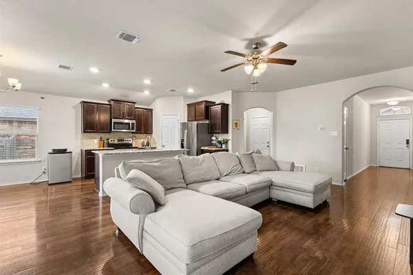 a living room with furniture kitchen view and a chandelier