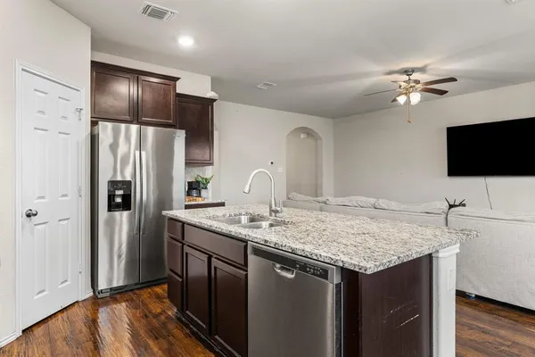 a kitchen with stainless steel appliances granite countertop a sink refrigerator and microwave
