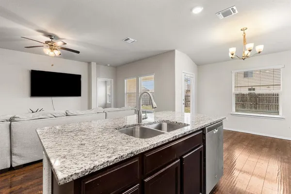 a kitchen with granite countertop a sink and a wooden floor