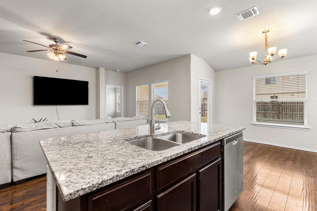 11233 Buzzard Gulch Drive Waco, TX 76708 - Photo 29 of 37 a kitchen with granite countertop a sink and a wooden floor