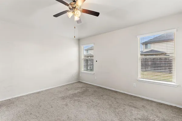 an empty room with a window and a fan