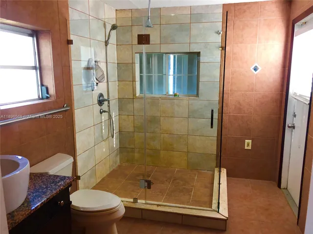 a bathroom with a shower a toilet and a sink