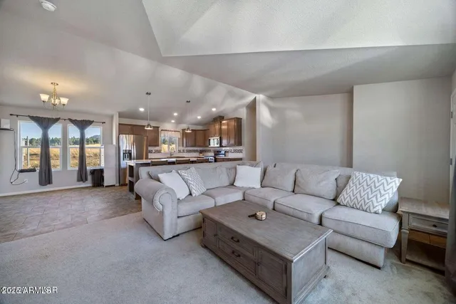 a living room with furniture and kitchen view