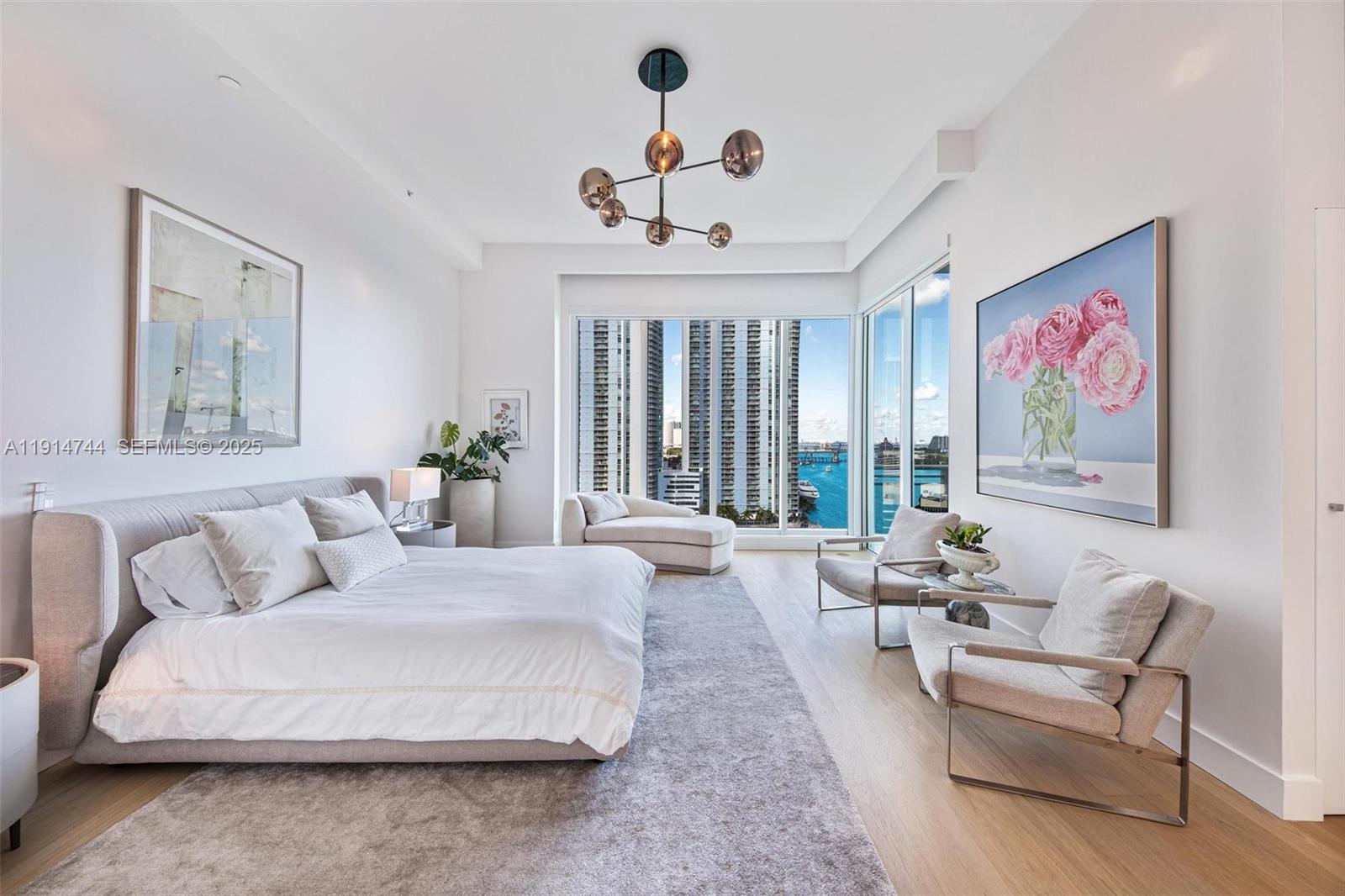 900 Brickell Key Boulevard, Unit 1403 Miami, FL 33131 - Photo 14 of 29 a living room with furniture large window and a chandelier