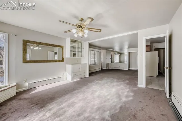 a view of a big room with chandelier fan and windows