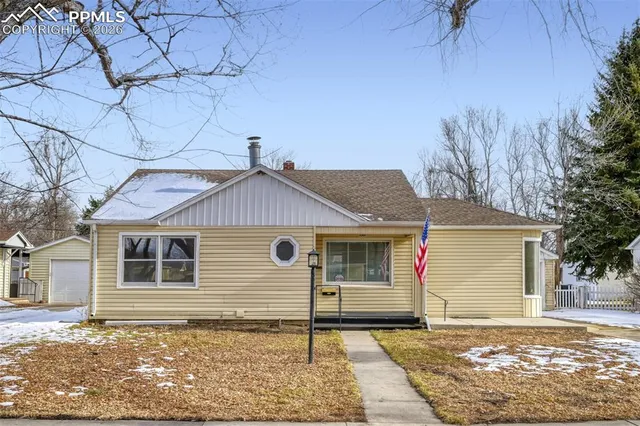 a front view of a house with a tree