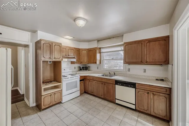 a kitchen with white cabinets and white appliances