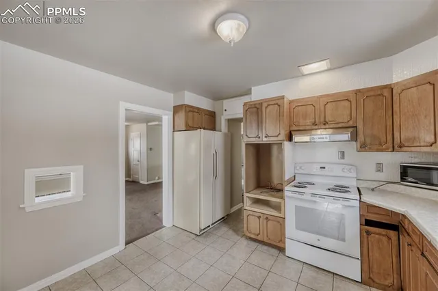 a kitchen with white cabinets and white appliances