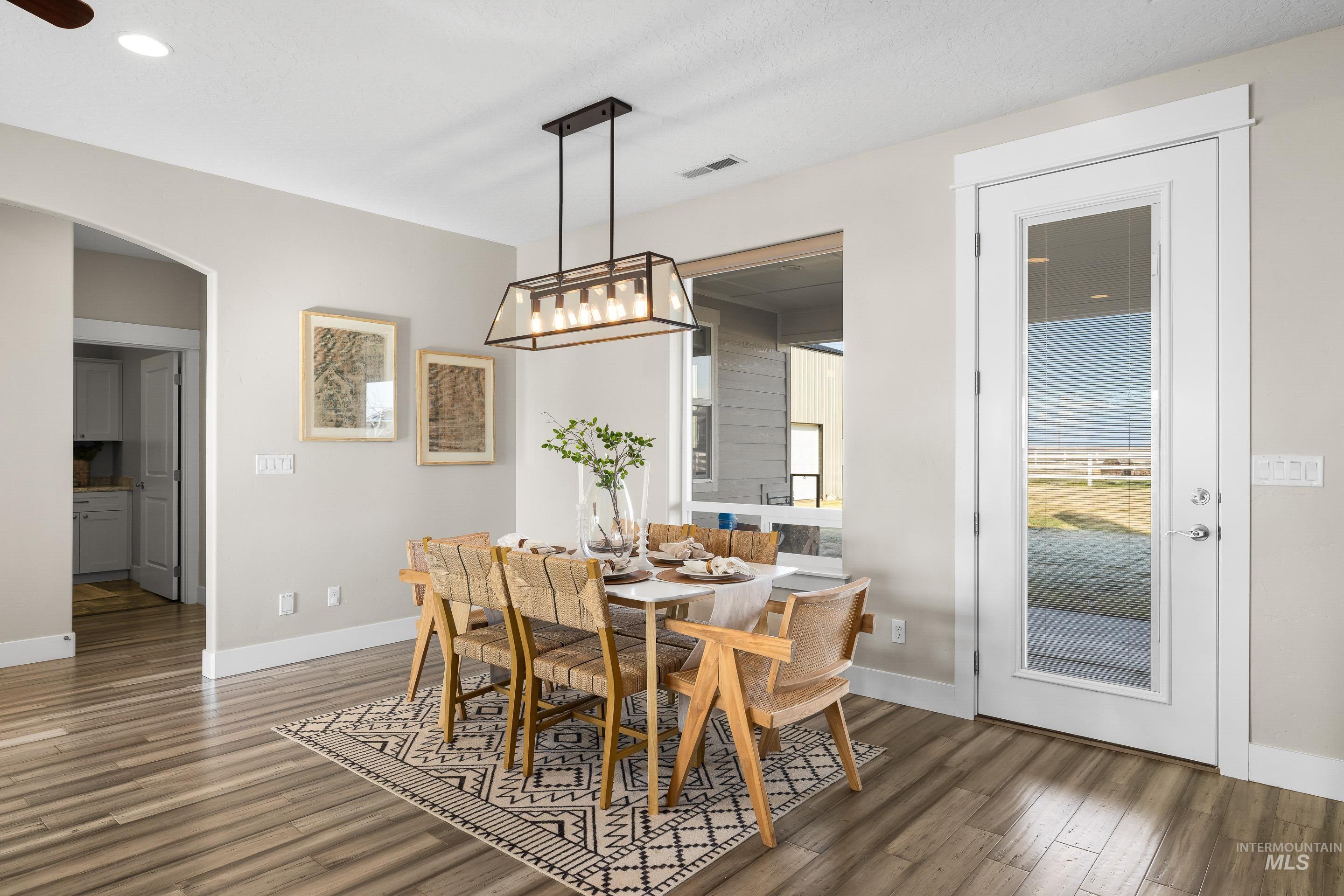 8018 Plumberry Court Middleton, ID 83644 - Photo 13 of 50 Dining room with arched walkways and dark wood finished floors