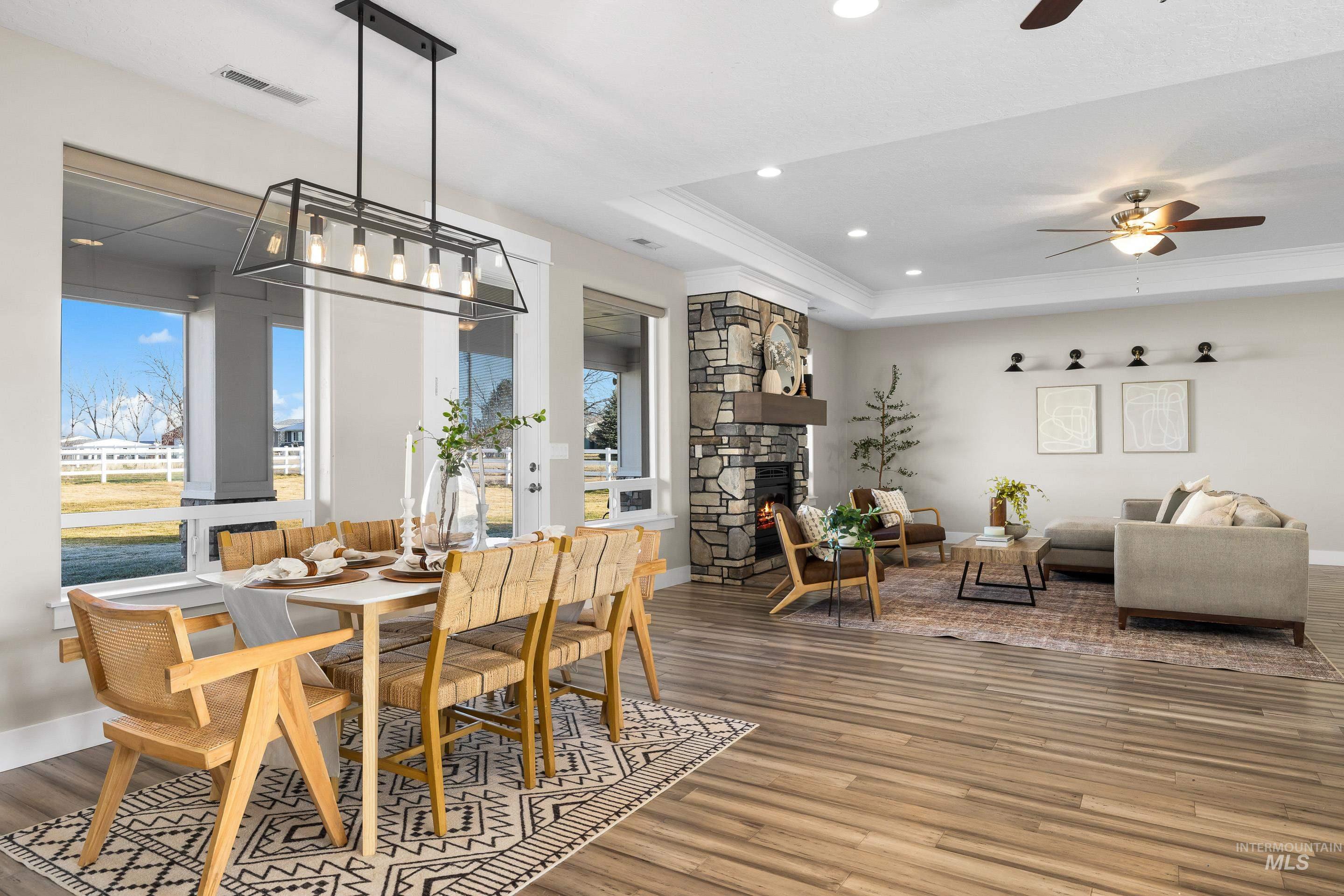 8018 Plumberry Court Middleton, ID 83644 - Photo 15 of 50 Dining space featuring a tray ceiling, a fireplace, wood finished floors, recessed lighting, and ceiling fan