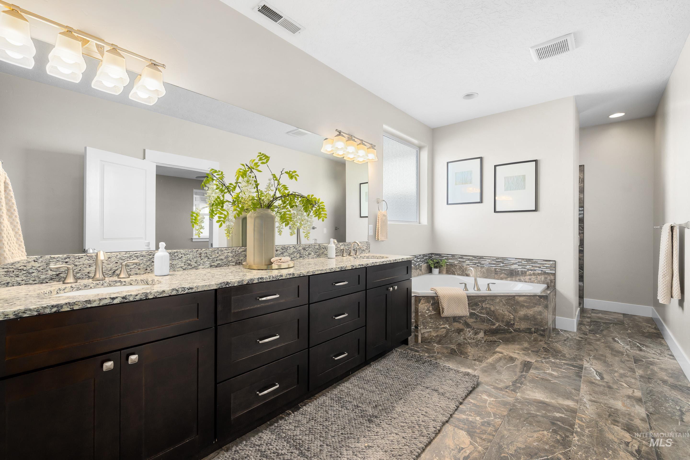 8018 Plumberry Court Middleton, ID 83644 - Photo 30 of 50 Full bathroom with double vanity, a garden tub, and dark marble finish floors