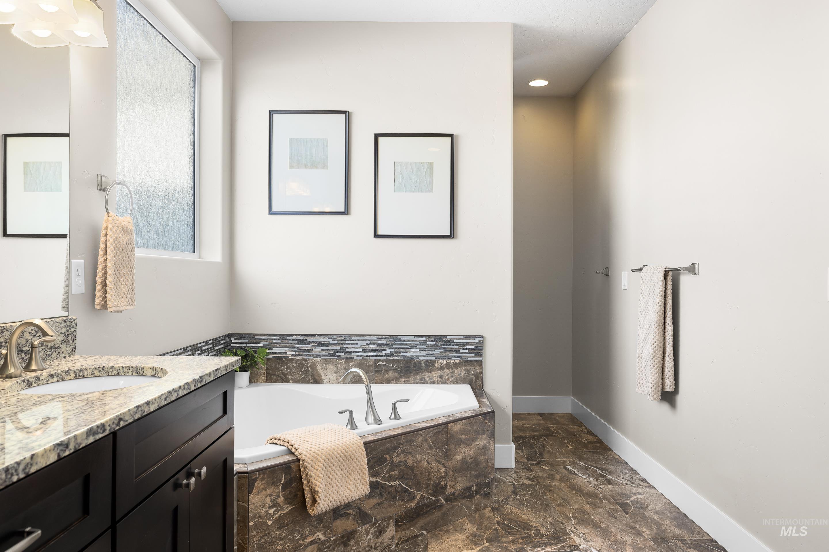 8018 Plumberry Court Middleton, ID 83644 - Photo 32 of 50 Bathroom with vanity, a bath, dark marble finish flooring, and recessed lighting