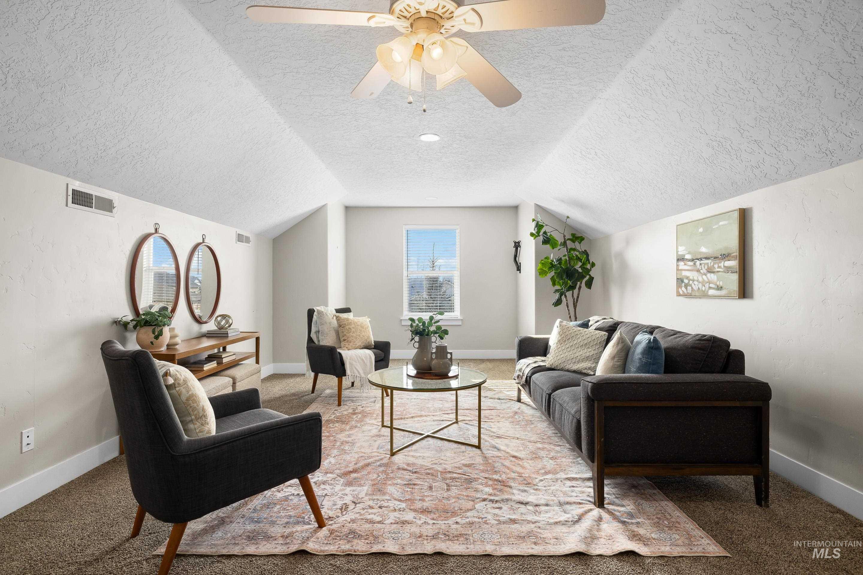 8018 Plumberry Court Middleton, ID 83644 - Photo 36 of 50 Carpeted living area with a textured ceiling, vaulted ceiling, ceiling fan, and a textured wall