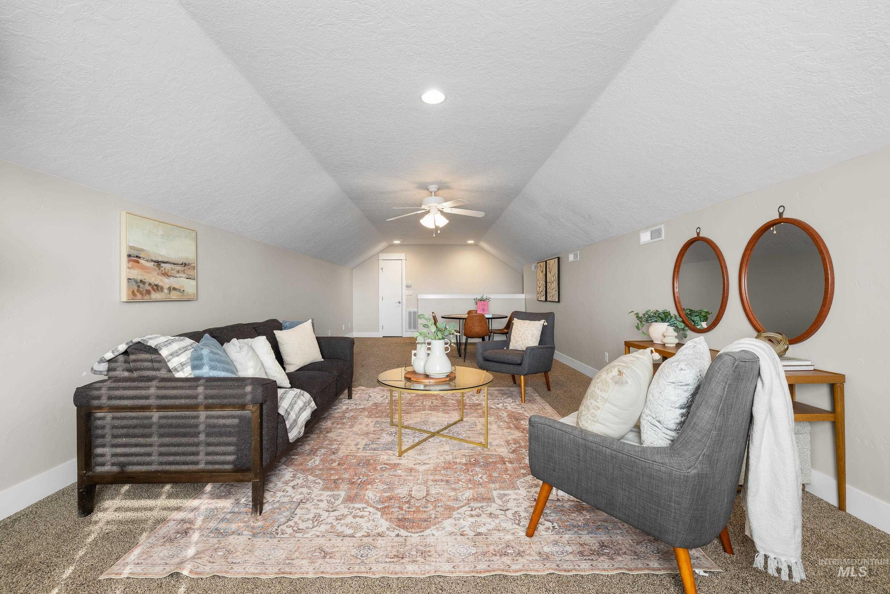 8018 Plumberry Court Middleton, ID 83644 - Photo 37 of 50 Living room with light carpet, a textured ceiling, lofted ceiling, and a ceiling fan