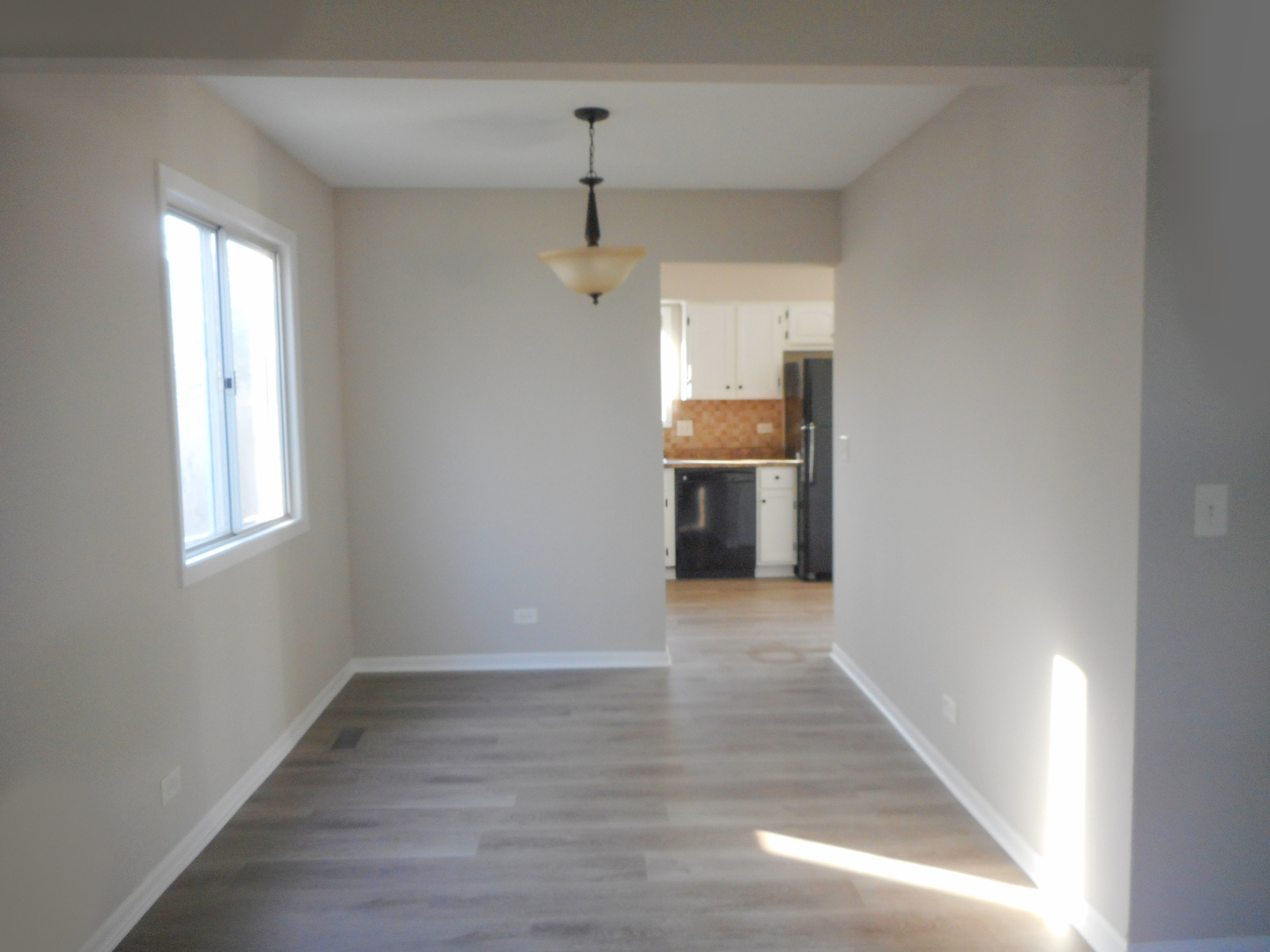 1318 Antigo Trail Carol Stream, IL 60188 - Photo 8 of 23 a view of an empty room with wooden floor fridge and a window