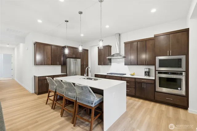 a large kitchen with a table chairs refrigerator and microwave