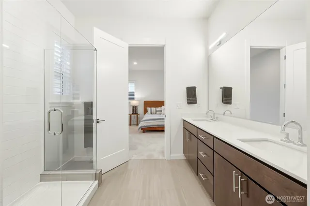 a en suite bathroom with a double vanity sink a mirror and shower