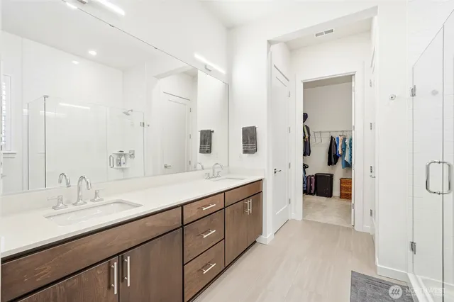 a spacious bathroom with a double vanity sink mirror double and shower
