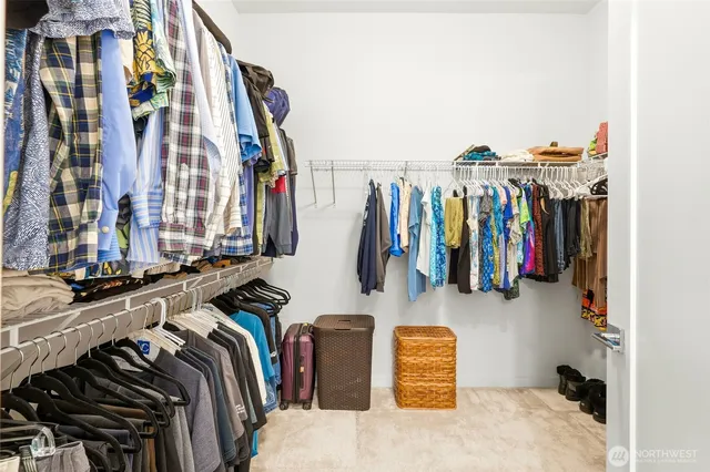 a view of walk in closet with clothes and shoes