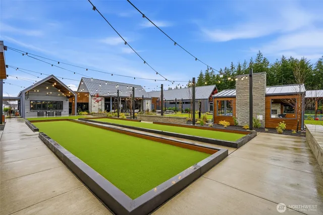 a view of swimming pool with lawn chairs and large tree
