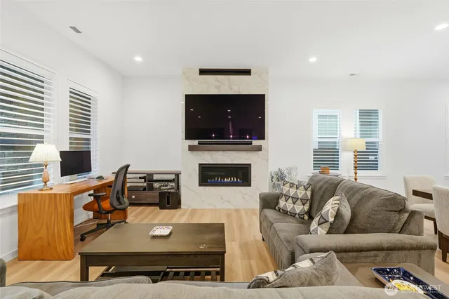 a living room with furniture a flat screen tv and a fireplace