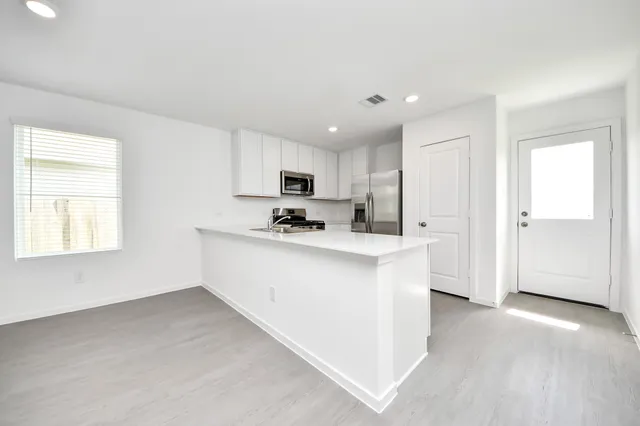 a kitchen with granite countertop white cabinets and stainless steel appliances